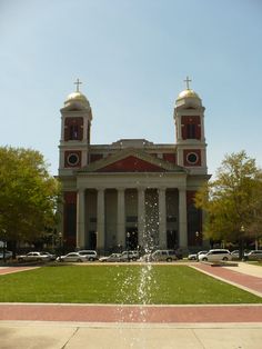 a fountain in front of a building with two towers