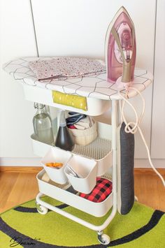 the ironing board is on top of an ironing board with several items in it