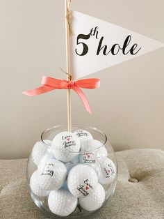 a glass bowl filled with golf balls and a sign that says 5 shoe on it