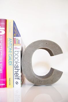 there is a bookend made out of concrete and some books on the shelf next to it