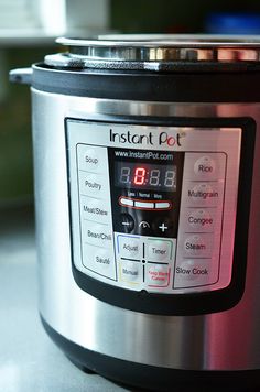 an instant pot on a counter top with the time displayed in red and black numbers