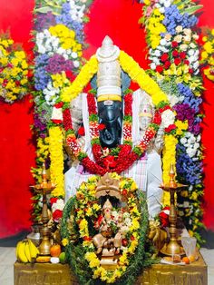 the statue is surrounded by flowers and candles