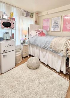 a bedroom with a bed, desk and microwave