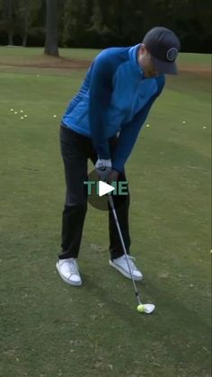 a man in blue shirt and black pants playing golf