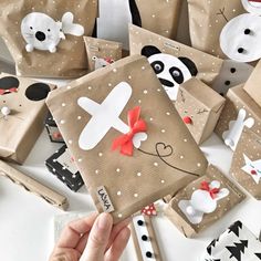 someone is holding up some brown paper bags with pandas on them and snowmen in the background