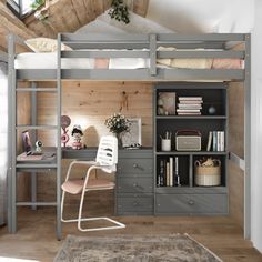 a loft bed with desk and chair in the corner, next to a book shelf