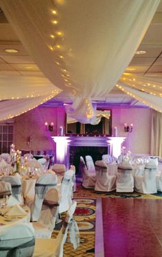 the banquet room is decorated with white linens and draping