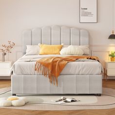 a white bed sitting on top of a hard wood floor next to a wall mounted clock