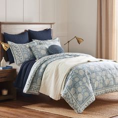 a bed with blue and white comforters in a bedroom