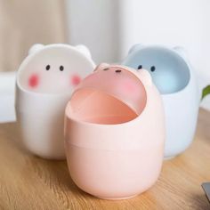 three little pig shaped cups sitting on top of a wooden table