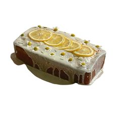 a piece of cake with lemons on top and white frosting, sitting in front of a white background