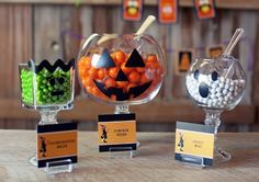 three halloween candy dispensers sitting on top of a wooden table