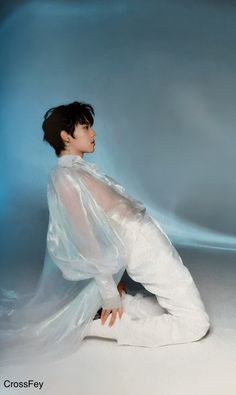 a woman sitting on the ground in white clothing