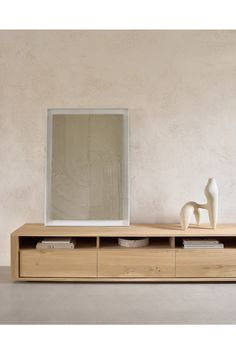 a white sculpture is sitting on top of a wooden shelf next to a large mirror