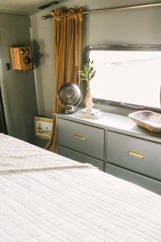 a bedroom area with a bed, dresser and window in the back wall is shown