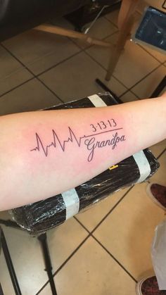 a woman's arm with a heartbeat tattoo and the words grandpa written on it