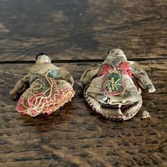 two cloth dolls sitting on top of a wooden table