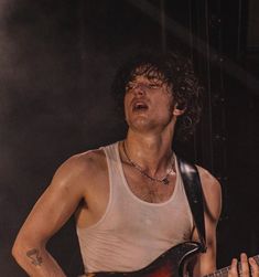 a young man playing an electric guitar on stage