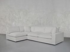 a white couch sitting on top of a gray floor