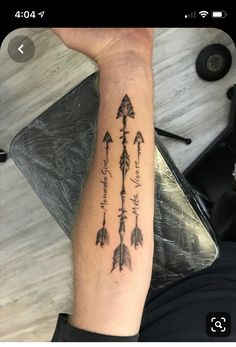 a person with a tattoo on their arm that has arrows and words written in it