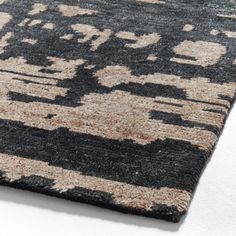 a black and beige rug on a white surface