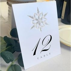 a table number card with a snowflake design on it and the number twelve