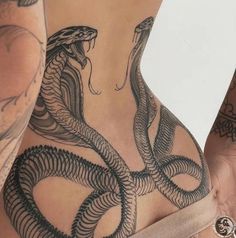 a woman with tattoos on her stomach has a snake tattoo on her back and side