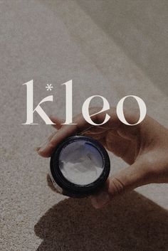 a person holding an object in their hand with the word kleo on it