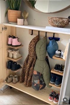 a closet filled with lots of shoes next to a wall mounted mirror and potted plant