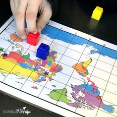 a person is playing a board game with colored blocks on the map and yellow markers