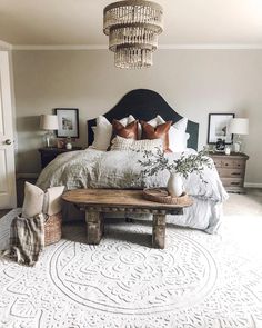 a bedroom with a large bed and chandelier hanging from the ceiling