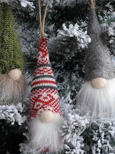 three gnome ornaments hanging from a christmas tree