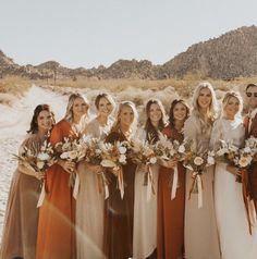 a group of women standing next to each other in front of a desert mountain range