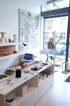 a room filled with lots of different items on top of white shelves next to a window