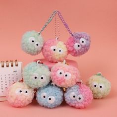 a group of small stuffed animals sitting next to a calendar on a pink tablecloth