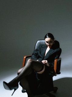 a woman sitting in a chair with her legs crossed