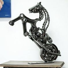 a sculpture of a motor bike on top of a wooden table next to a painting