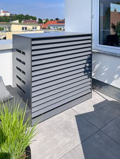 an outdoor bar on the side of a building next to a planter and potted plants