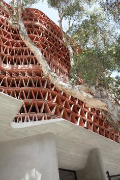 a building made out of red bricks with trees in the background