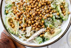 a white plate topped with lettuce and chickpeas