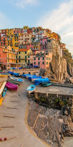 several boats are parked on the shore in front of some buildings with colorfully colored windows