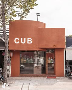 a building with a sign that says cub on the front and two bicycles parked outside