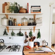 a white stove top oven sitting next to a wooden counter topped with pots and pans