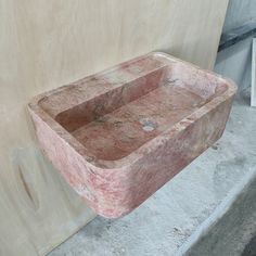 a stone sink sitting next to a wall