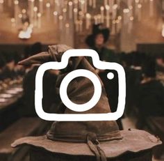 a camera sitting on top of a wooden table in front of a chandelier