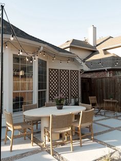 an outdoor dining area with patio furniture and string lights