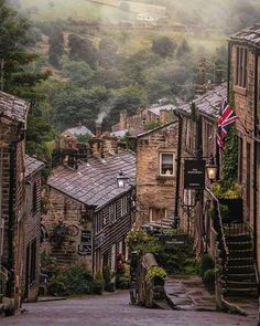 an old town with stone buildings and flags hanging from the building's roof tops