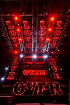 the stage is lit up with red lights and words that spell out love on it