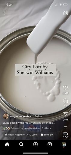 a white paint can being poured onto the floor by a brush with city loft by sherwin williams on it