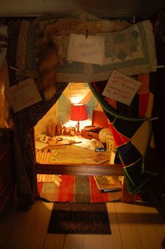 a bed with lots of pillows on top of it and a lamp in the corner